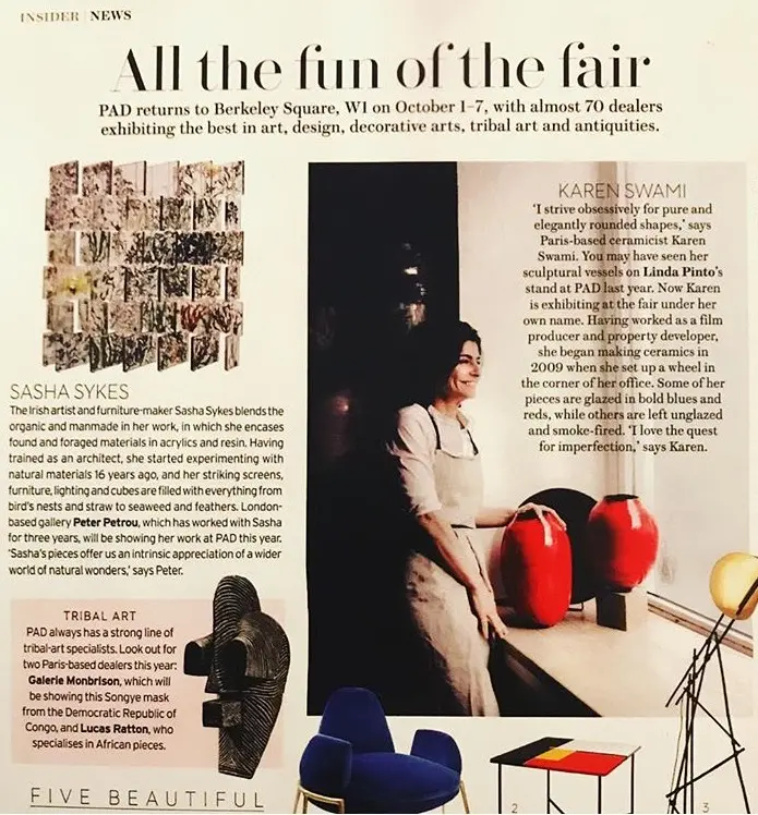 press exhibition ceramics paris, portrait of ceramist karen swami at the pad london fair, surrounded by her handmade red stoneware pieces, emblematic of refined and contemporary parisian creation