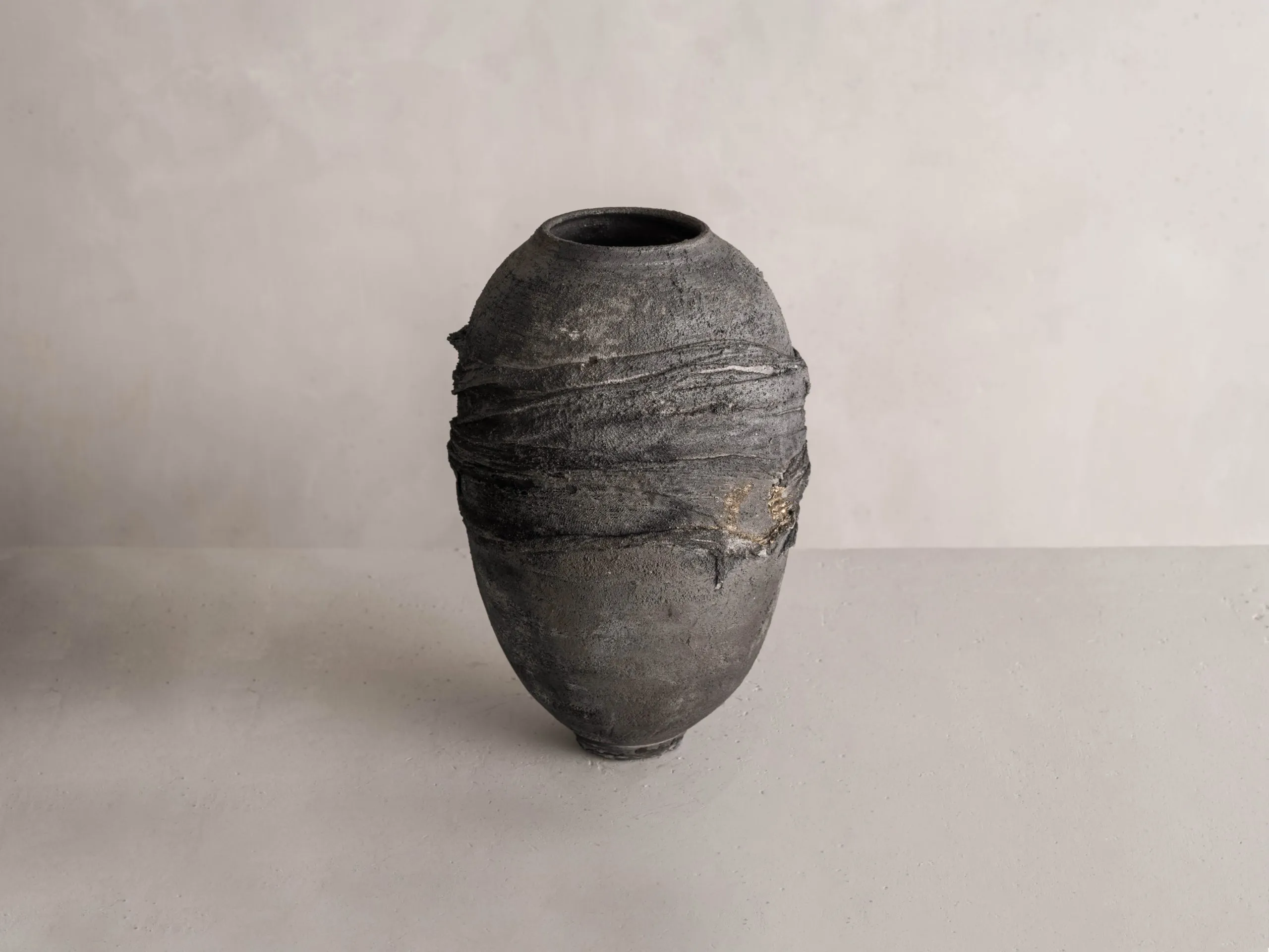 vase en argile nue, modelé à la main, dans l’atelier parisien, texture brute et teinte sombre, pour une décoration en céramique authentique et contemporaine