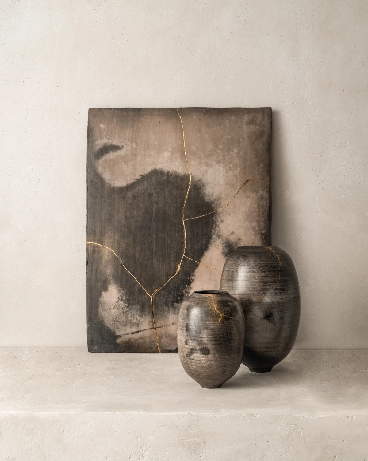 vase en céramique noire et tableau céramique restaurés au Kintsugi, décor minimaliste en grès enfumé, objets d’art faits main, techniques japonaises et savoir-faire français, céramique contemporaine, pièce unique de design luxe, contraste poétique entre fragilité et réparation